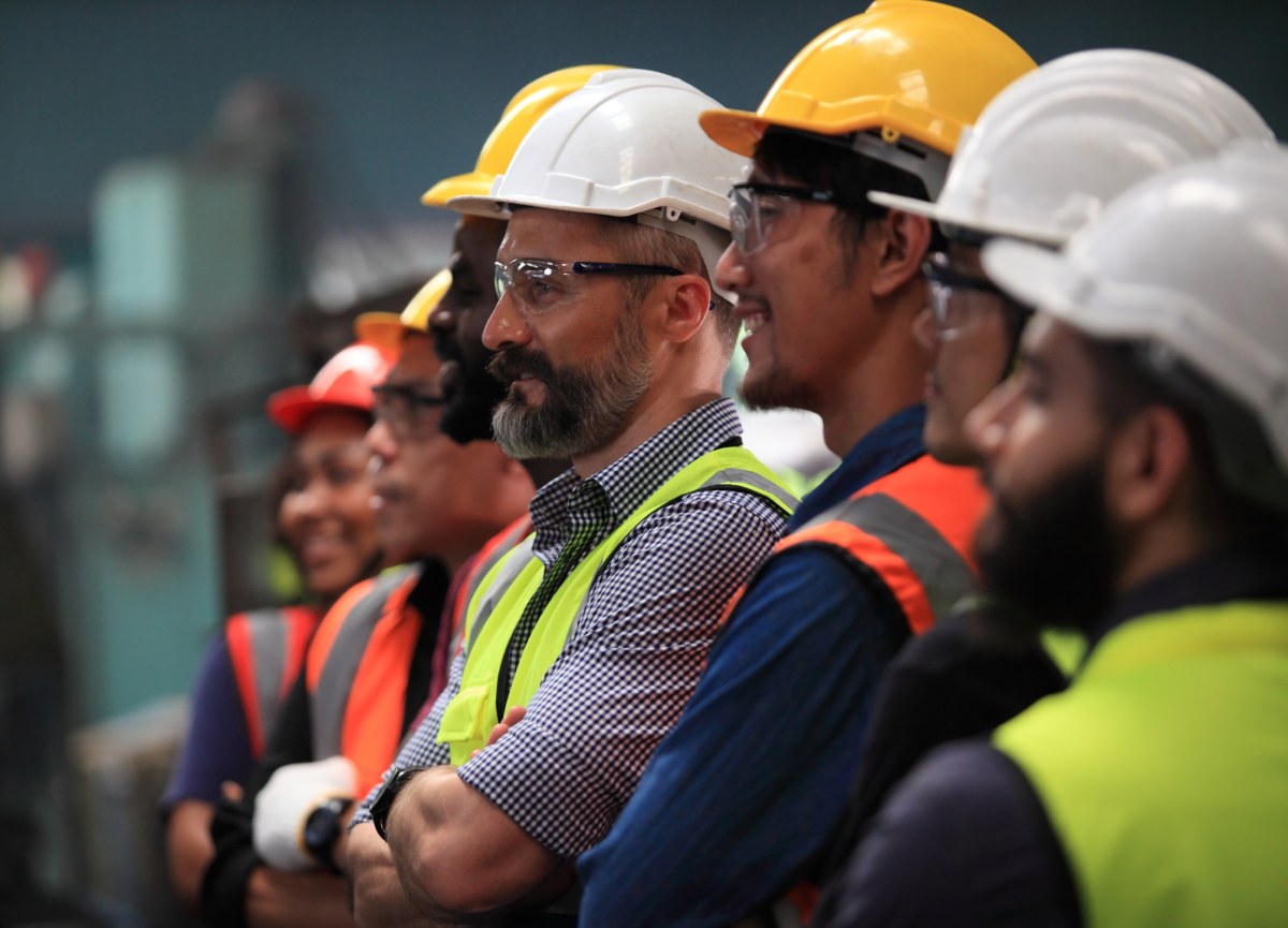 A group of construction workers in a meeting about liability insurance and workplace safety